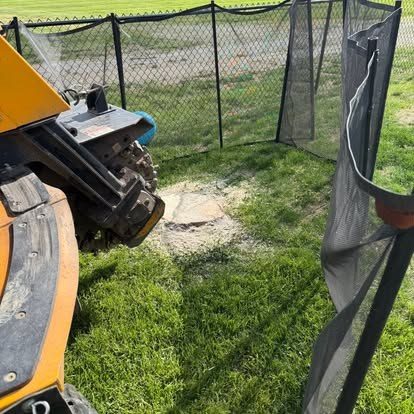 Stump grinder throwing chips mid-grind on a Central Indiana property