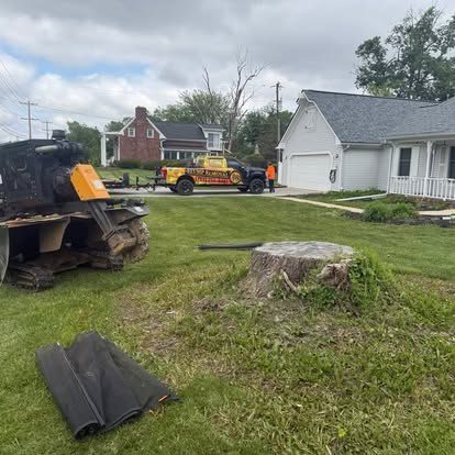 Large cut stump and grinder ready to work beside a Central Indiana house