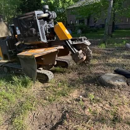 Triple B's stump grinder removing a tree stump with debris flying in a Central Indiana yard